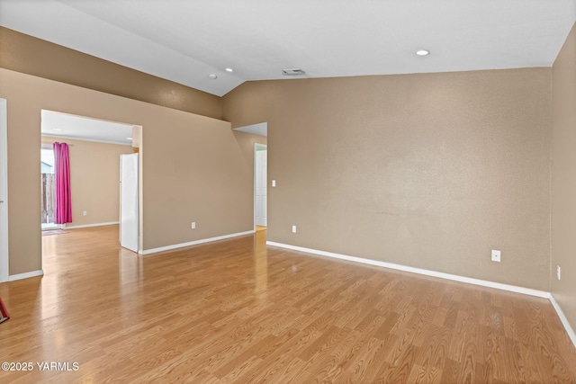 unfurnished room with lofted ceiling, visible vents, baseboards, and light wood finished floors