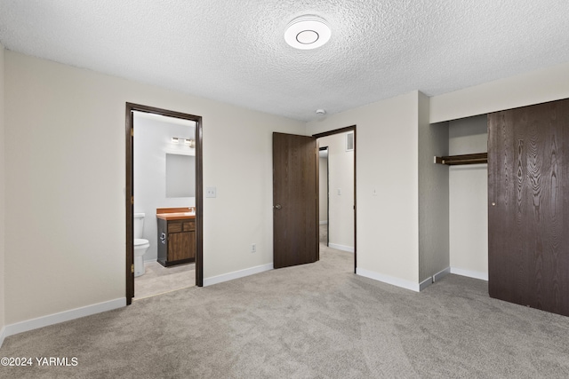 215 S Ridgeway Dr, Yakima, WA 98901 - unfurnished bedroom featuring a closet, ensuite bathroom, light colored carpet, a textured ceiling, and baseboards