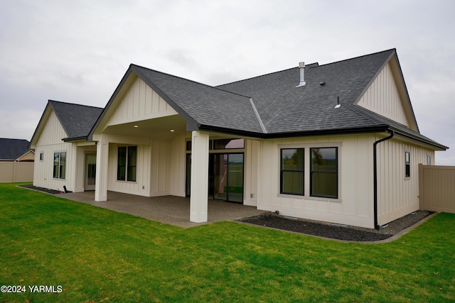 rear view of house with a patio area, a shingled roof, fence, and board and batten siding