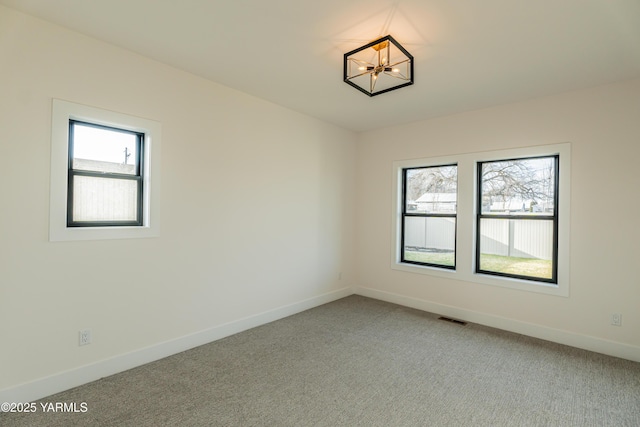 unfurnished room with baseboards, visible vents, and carpet flooring