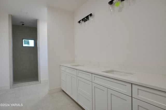 bathroom with tile patterned floors, walk in shower, baseboards, and double vanity