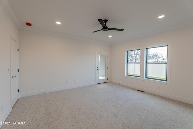 empty room featuring baseboards, visible vents, crown molding, and light colored carpet