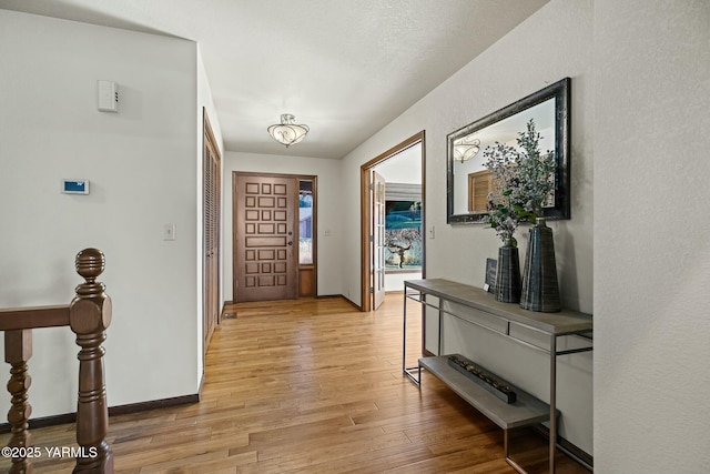 entrance foyer with light wood-style floors and baseboards