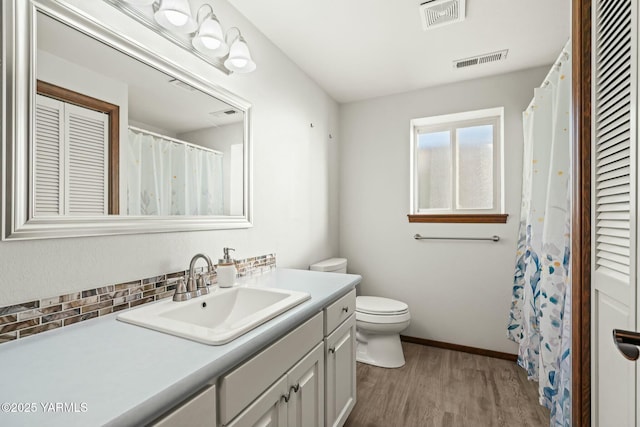 bathroom featuring a closet, visible vents, vanity, and wood finished floors