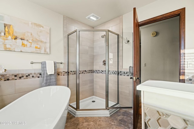 full bath with visible vents, a freestanding bath, and a shower stall