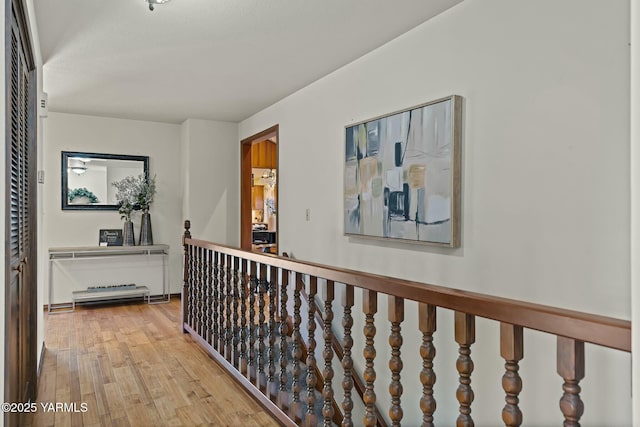 hall featuring light wood-style floors and an upstairs landing