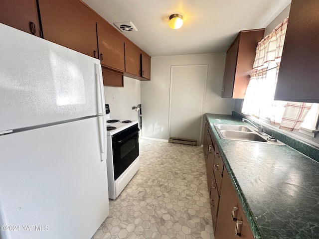 kitchen featuring dark countertops, electric range oven, brown cabinetry, freestanding refrigerator, and a sink