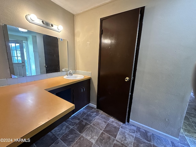 bathroom with a textured wall and vanity