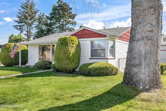 view of front of home with a front lawn and roof with shingles