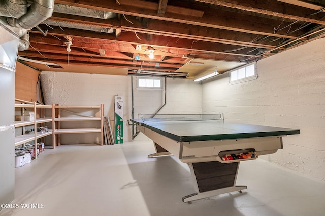 rec room with concrete block wall, a healthy amount of sunlight, and finished concrete floors