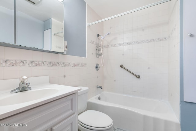 full bath featuring toilet, bathtub / shower combination, tile walls, visible vents, and vanity