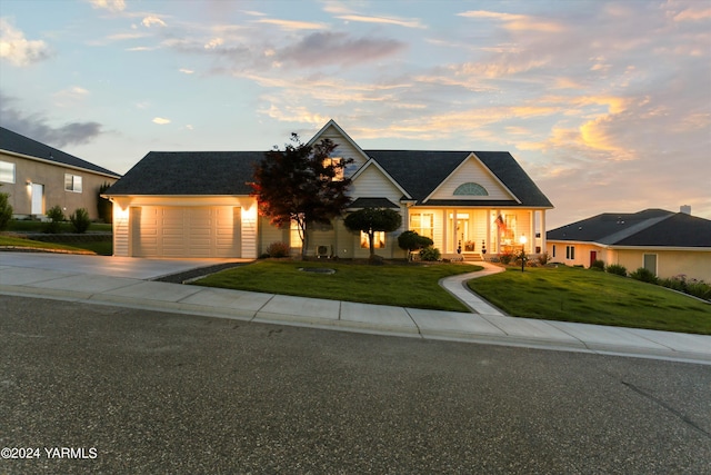 view of front of house featuring a garage, driveway, and a lawn