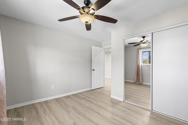 unfurnished bedroom featuring wood finished floors, a closet, baseboards, and a ceiling fan