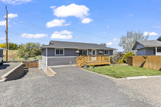 view of front facade featuring a wooden deck and gravel driveway