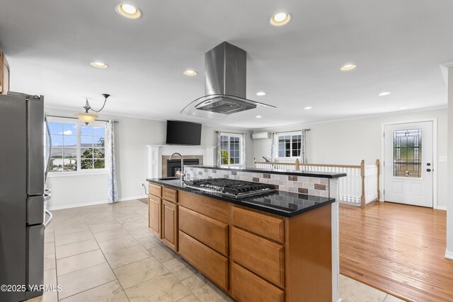 kitchen featuring stainless steel appliances, island range hood, crown molding, recessed lighting, and baseboards