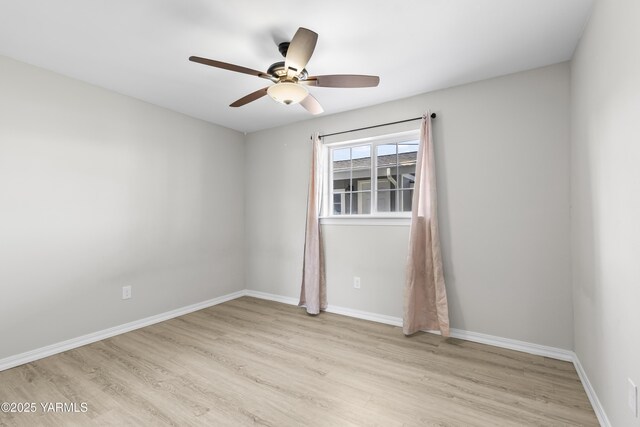 unfurnished room with ceiling fan, wood finished floors, and baseboards