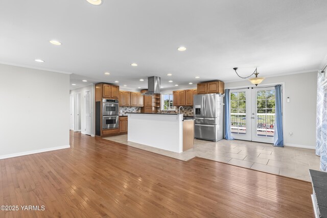kitchen featuring appliances with stainless steel finishes, island range hood, crown molding, decorative backsplash, and recessed lighting