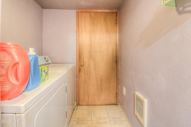 clothes washing area with washer and dryer, laundry area, and light tile patterned floors