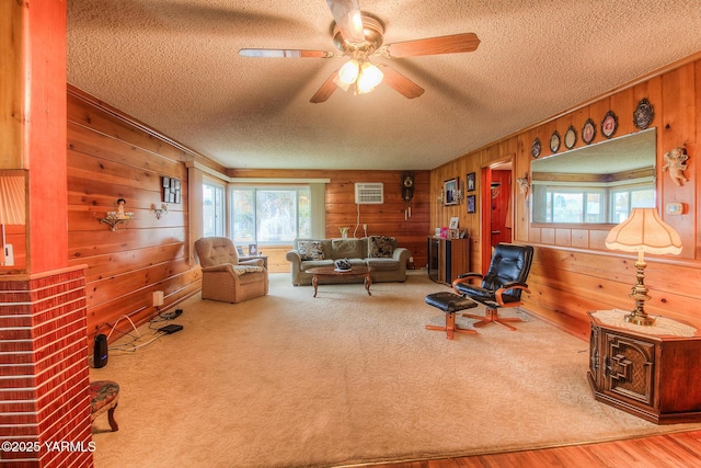 carpeted living room with a textured ceiling, a ceiling fan, a wealth of natural light, and wooden walls