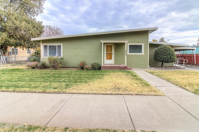 single story home with a front yard and fence