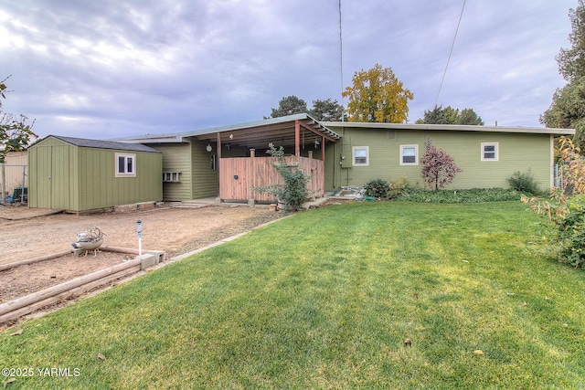 back of property featuring an outbuilding, a shed, and a lawn