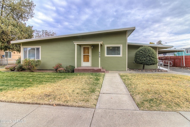 ranch-style home featuring a front yard and fence