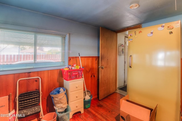 interior space featuring a wainscoted wall, wood finished floors, and wooden walls