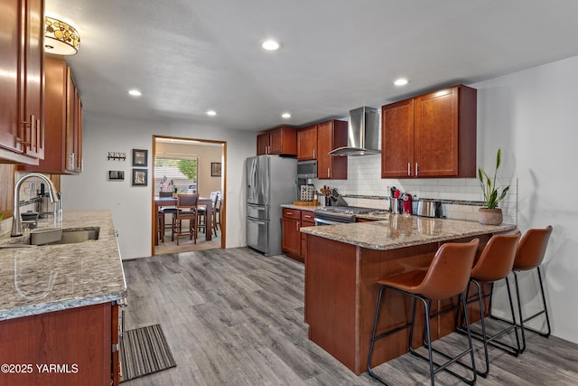 3603 Carol Ave, Yakima, WA 98902 - kitchen with wall chimney exhaust hood, a sink, stainless steel appliances, tasteful backsplash, and wood finished floors