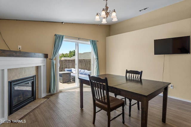 710 Columbus Ave, Moxee, WA 98936 - dining area featuring a chandelier, vaulted ceiling, wood finished floors, and a tiled fireplace