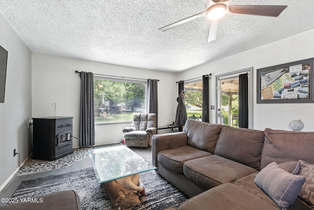 310 Sage Trail Rd, Yakima, WA 98901 - living area with wood finished floors, a wood stove, a textured ceiling, a ceiling fan, and baseboards