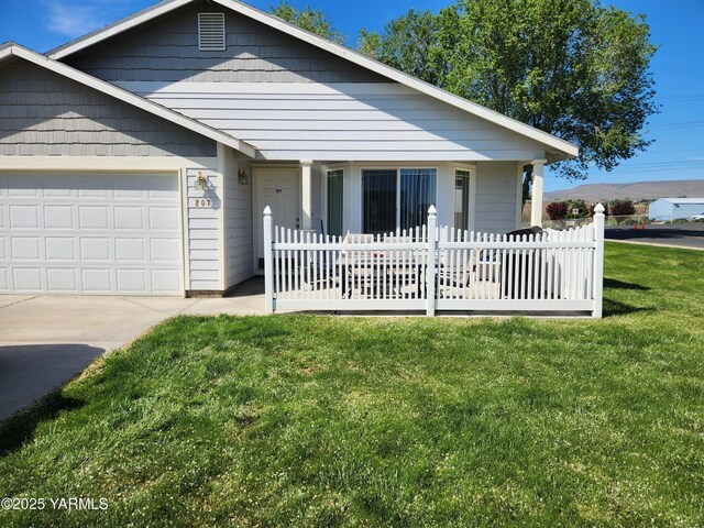 view of front of home featuring a front lawn, an attached garage, driveway, and covered porch