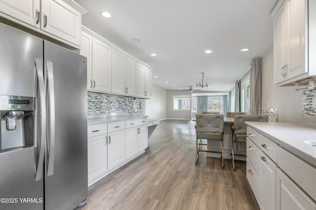 851 E Selah Rd, Yakima, WA 98901 - kitchen featuring stainless steel refrigerator with ice dispenser, backsplash, white cabinetry, light wood finished floors, and light countertops