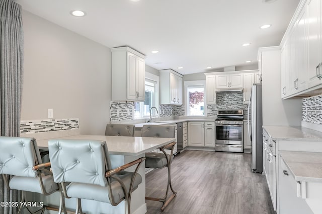 851 E Selah Rd, Yakima, WA 98901 - kitchen featuring stainless steel appliances, a sink, decorative backsplash, light wood-type flooring, and recessed lighting