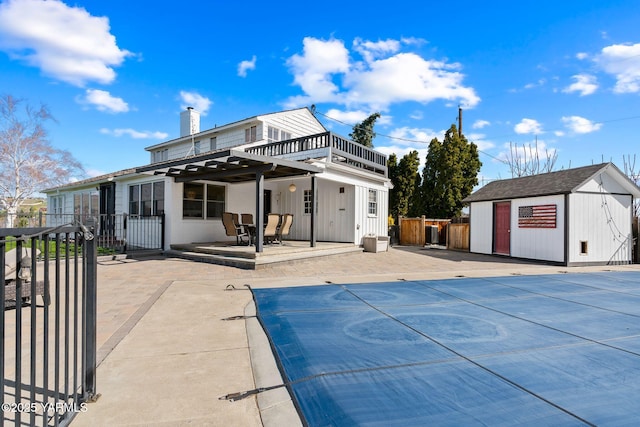 5 N 80th Ave, Yakima, WA 98908 - rear view of house with a community pool, a chimney, an outdoor structure, fence, and a patio