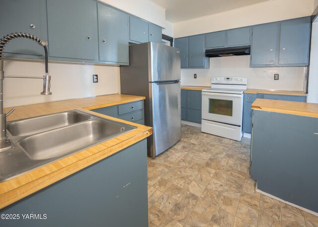 1309 W Spruce St, Yakima, WA 98902 - kitchen with white range with electric cooktop, under cabinet range hood, freestanding refrigerator, blue cabinets, and a sink