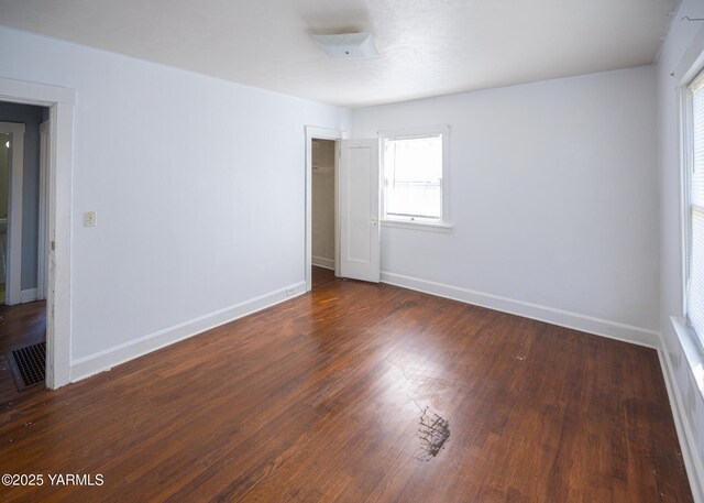 1309 W Spruce St, Yakima, WA 98902 - unfurnished bedroom with dark wood finished floors, multiple windows, and baseboards