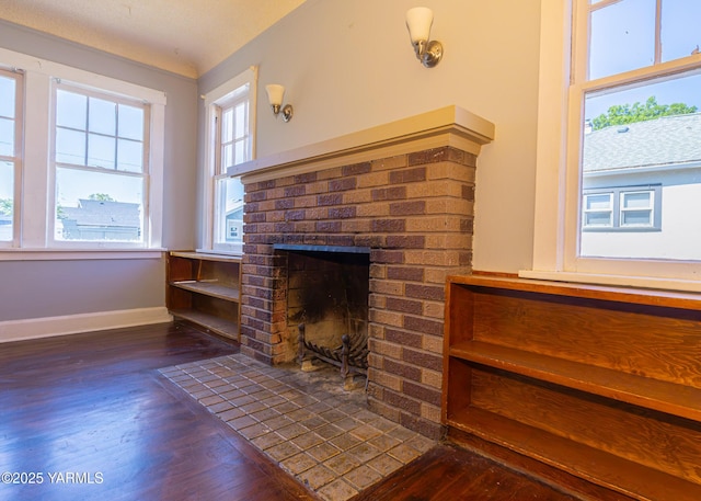1309 W Spruce St, Yakima, WA 98902 - unfurnished living room with wood finished floors, baseboards, and a brick fireplace