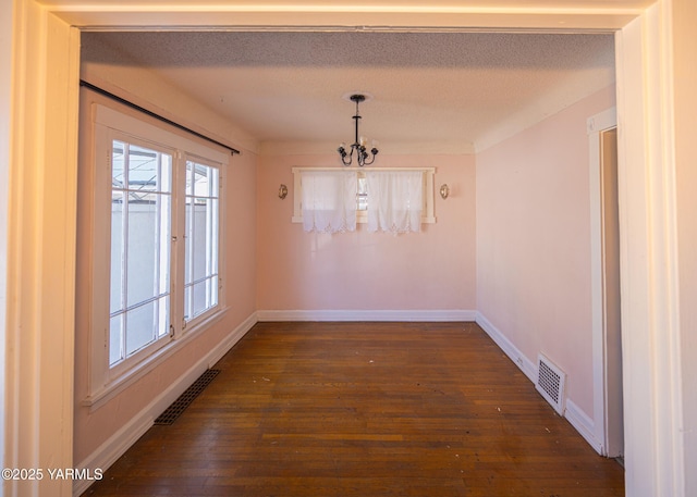 1309 W Spruce St, Yakima, WA 98902 - unfurnished dining area with a chandelier, baseboards, dark wood-style floors, and a textured ceiling