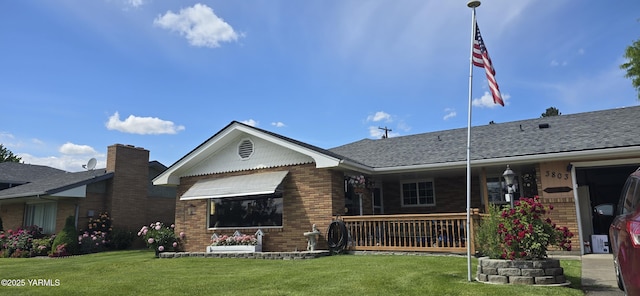 3803 Meadow Ln, Yakima, WA 98902 - rear view of house featuring brick siding, a lawn, a porch, and roof with shingles