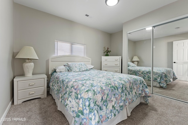 carpeted bedroom with a closet, visible vents, and baseboards