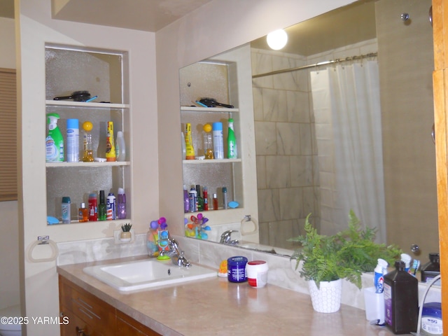 bathroom featuring a tile shower and vanity