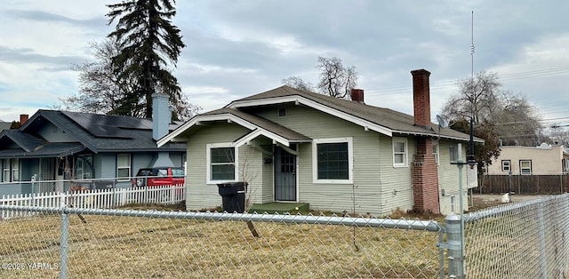 bungalow with fence private yard, a chimney, and a front lawn