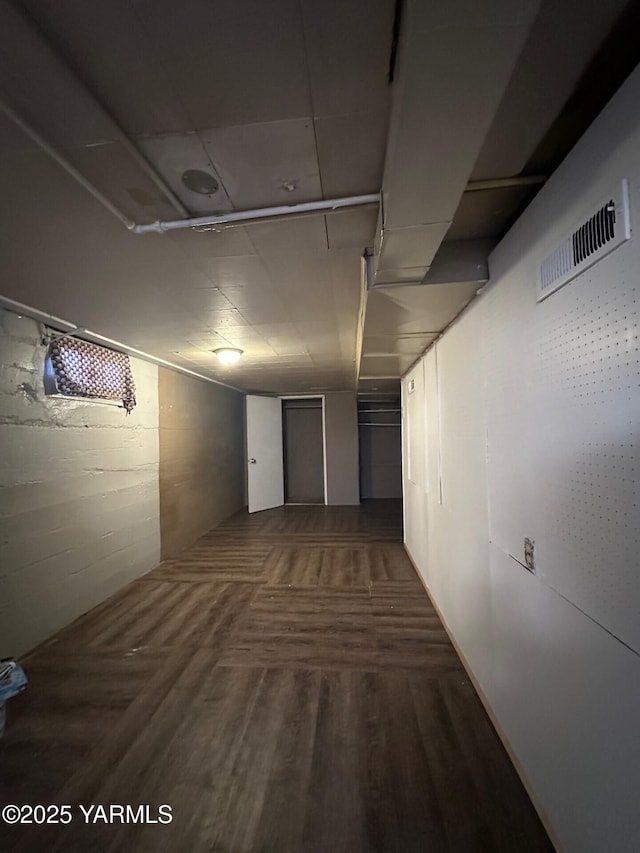 hall featuring dark wood-type flooring and visible vents