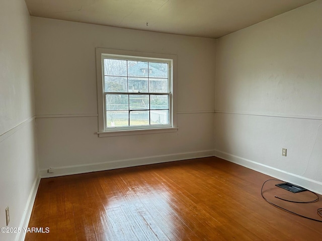 empty room featuring baseboards and wood finished floors