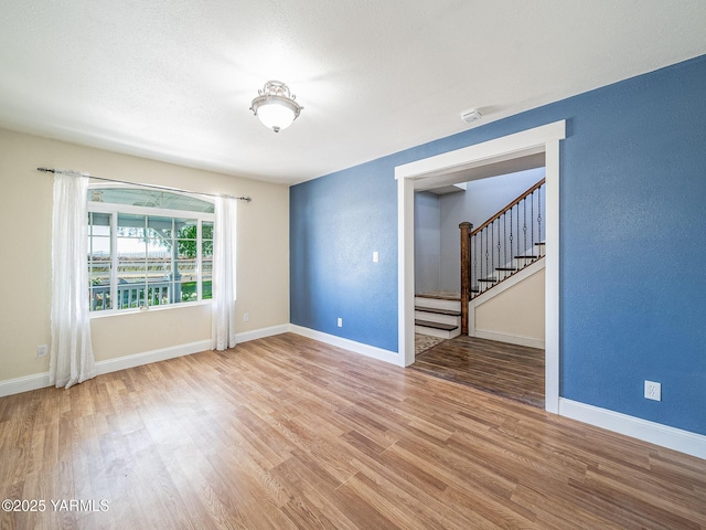 230 Krough Rd, Prosser, WA 99350 - empty room with baseboards, a textured wall, stairs, and wood finished floors