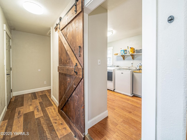 230 Krough Rd, Prosser, WA 99350 - hall with separate washer and dryer, a barn door, light wood finished floors, and baseboards
