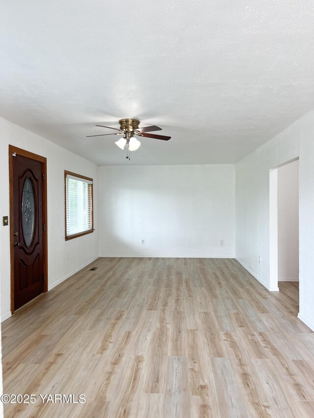 63 W Mead Ave, Yakima, WA 98902 - unfurnished living room featuring ceiling fan, light wood-type flooring, and baseboards