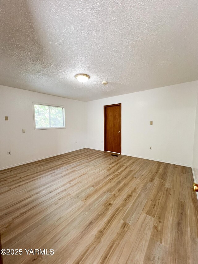 63 W Mead Ave, Yakima, WA 98902 - spare room with light wood-type flooring, a textured ceiling, and baseboards