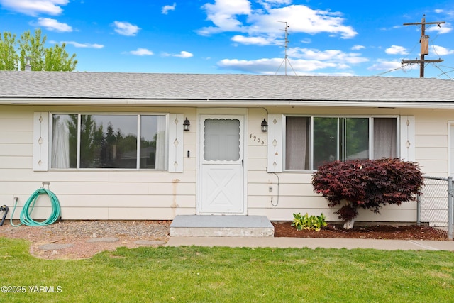 4905 Glenside Ct, Yakima, WA 98908 - view of exterior entry featuring a lawn and a shingled roof