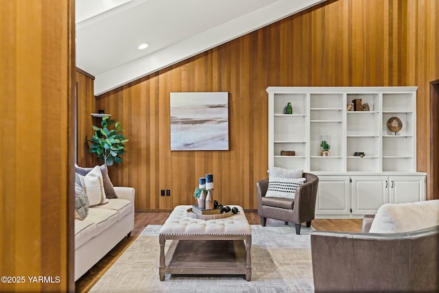 living area with wood finished floors and wooden walls